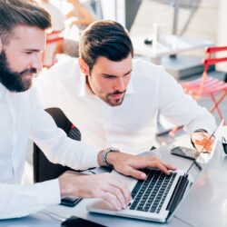 two businessmen outdoor using technology