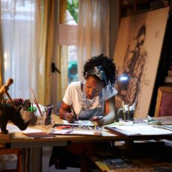 Young African-American artist at work in the studio. Creative person making art.